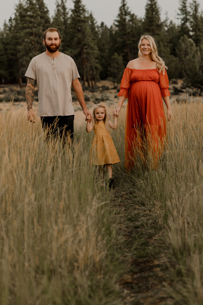 maternity photography session at Indian meadows in sisters oregon, family standing together smiling